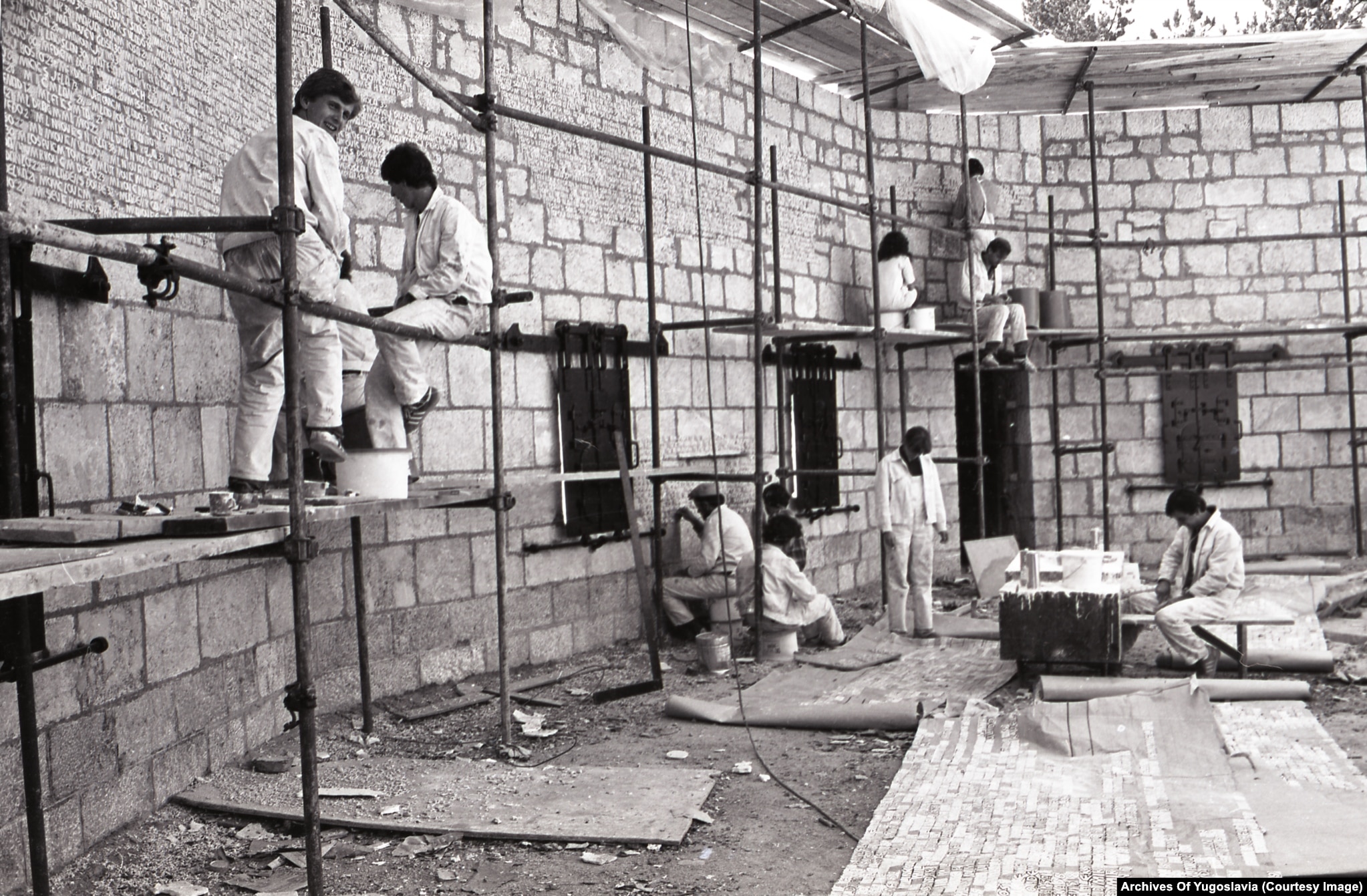 Arbeiter meißeln beschriftete Namenstafeln in Steinblöcke auf einer Hangterrasse in Vraca, 1981.